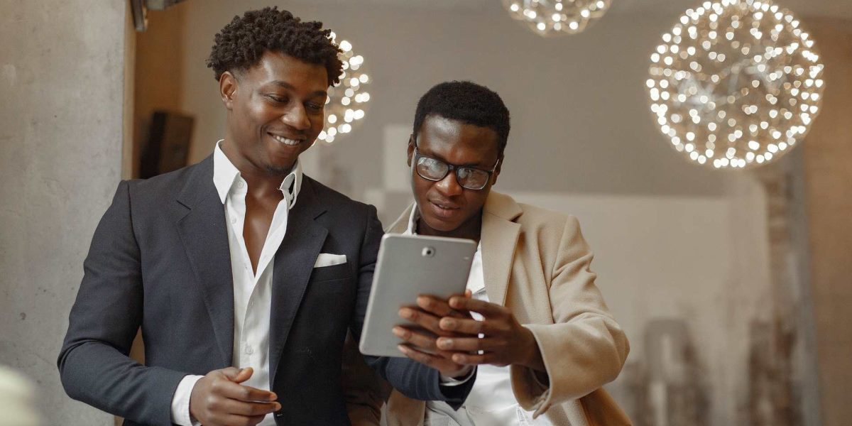 zwei Menschen, die fröhlich auf ein Tablet schauen